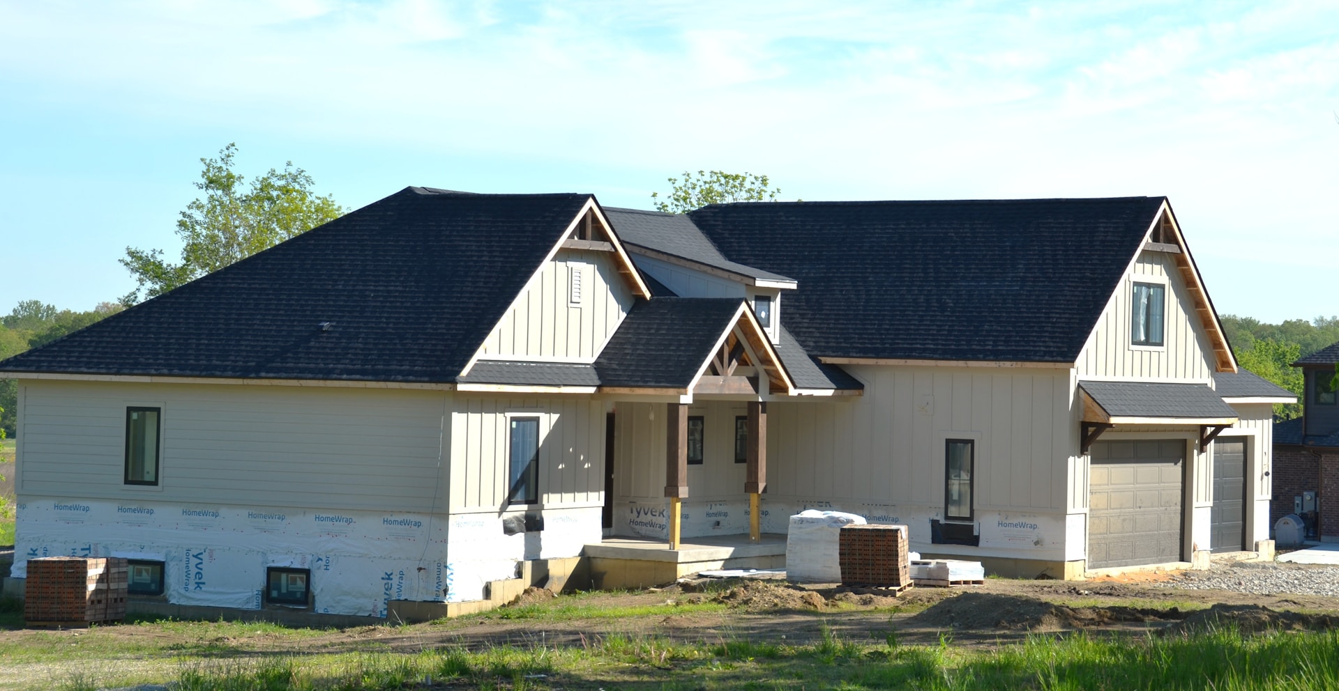 A new house under construction with a dark roof, illustrating the new-home building activity across the Four Corners, FL area